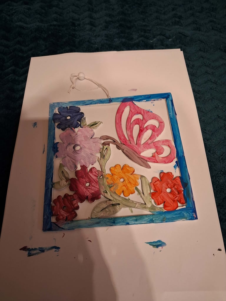 Handmade greeting card with watercolor flowers framed in blue border, featuring pink butterfly and colorful blooms on white cardstock