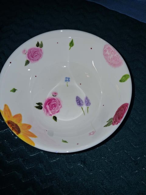 White ceramic plate with colorful floral design featuring pink roses, purple lavender, yellow sunflower, and green leaves scattered around the rim